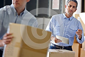 Manager Using Tablet Computer In Distribution Warehouse