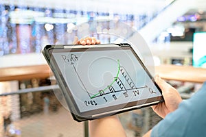 A manager using tablet to see business growth predication graph of 2021. photo