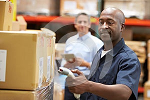 Manager In Warehouse With Worker Scanning Box In Foreground photo