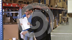 Manager And Worker Checking Goods In Warehouse