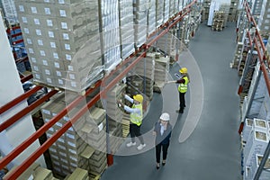 Manager and workers at warehouse, above view. Logistics center