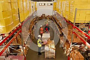 Manager and workers at warehouse, above view. Logistics center