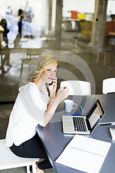 Manageress with mobile phone in office photo