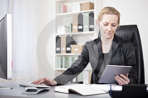 Manageress with Tablet Typing on Desktop Computer