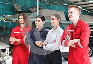 Managers and auto mechanic team standing with arms crossed in a repair garage, Car repair and maintenance concepts