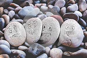 Managing emotions emoji faces on stones - sad, happy, surprised worried and angry feelings draw