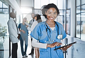 Managing her doctoring duties with digital tech. Portrait of a young doctor using a digital tablet in a hospital with