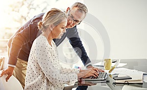 Managing their home finances with modern tech. a mature couple using a laptop while going through paperwork at home.