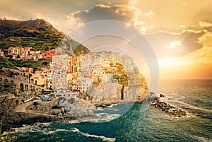 Manarola, Cinque Terre, Italy. Colorful traditional houses on a rock over Mediterranean sea on dramatic sunset