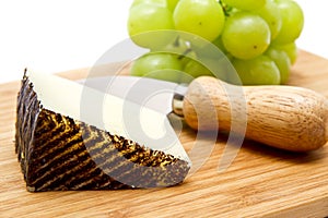 Manchego cheese ang grapes on chopping board photo