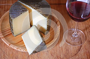 Manchego cheese, made in Spain accompanied by a glass of red wine