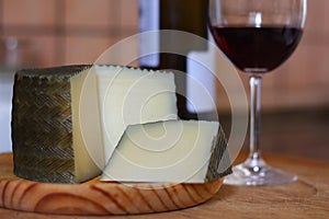 Manchego cheese, made in Spain accompanied by a glass of red wine