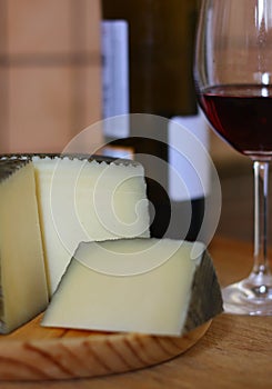 Manchego cheese, made in Spain accompanied by a glass of red wine
