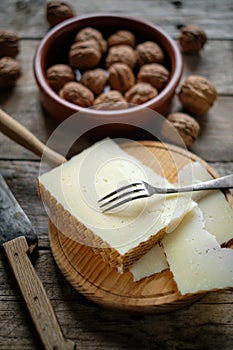 Manchego cheese and nuts on rustic wooden table