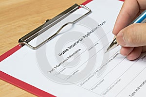 Mand fill the home insurance application form with red file photo