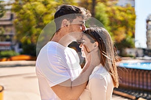 Mand and woman couple hugging each other and kissing at park