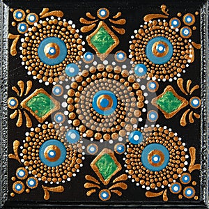 Mandala dot art painting on wood tiles. Beautiful mandala hand painted by colorful dots on black wood. National patterns