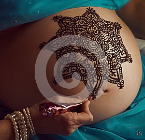 Mandala with henna on an pregnancy womanâ€™s belly