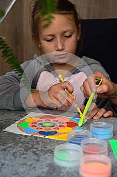 A mandala made of colored sand, the mom with the girls