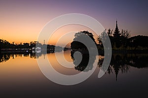 Mandalay Palace wall with reflection in moat, picturesque silhouette with twilight sky in sunset