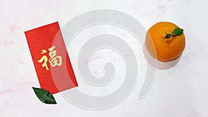 A mandarin orange with red ang pow