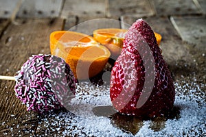 Mandarin, strawberry and chocolate on an old wooden table in an