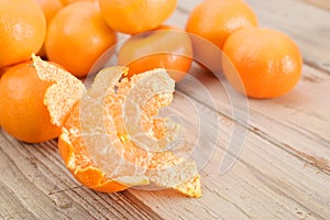 Mandarine or tangerine peeled on table