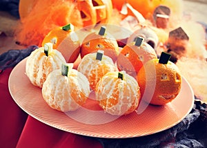 Mandarines ornamented as Halloween pumpkins