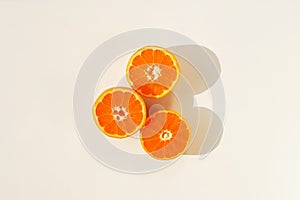 Mandarines, tangerine, clementine slices and shadows top view on white background