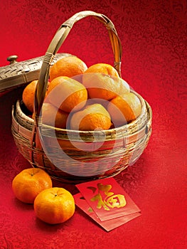 Mandarins in a basket and red packets in red clot photo