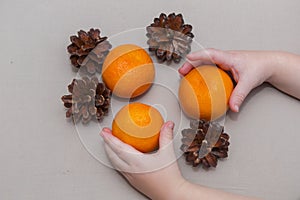 Mandarins and bumps in the hands of a child Christmas composition