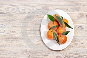 Mandarins on a plate. Still life with tangerines on wooden table