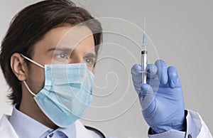 Mandatory Vaccination Concept. Closeup Of Male Doctor Holding Syringe With Vaccine photo