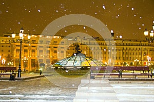 Manezhnaya square in the evening on a snowy winter in the light of lanterns