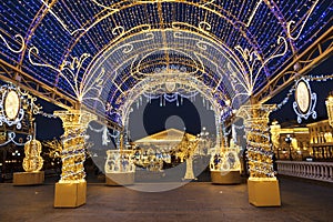 Manezhnaya square during New Year and Christmas holidays with glowing multi-colored arch, Moscow,