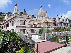 Mangal Dham Pranami Temple surrounded by a garden under the sunlight in Kalimpong, India