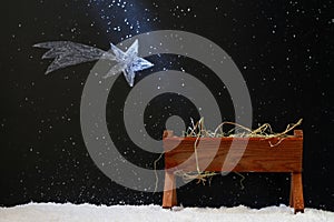 Manger and star of Bethlehem on snowy night, abstract christmas nativity scene concept