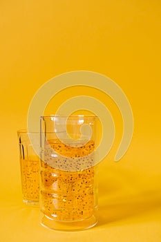 Mango drink with basil seeds on a yellow background. Refreshing drink with ice