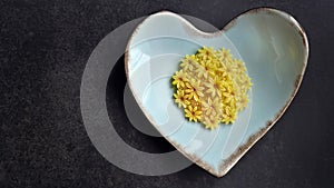 Mango flavor, Sam Pan Nee traditional Thai handcraft snack on pastel blue heart shape plate, Dark background, Royal famous Thai