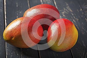 Mango fresh fruit on black wooden table photo