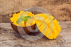 Mango fruit and mango cubes on the wooden table
