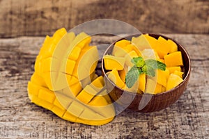 Mango fruit and mango cubes on the wooden table