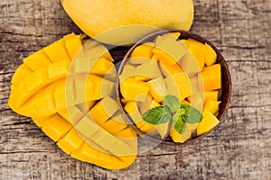 Mango fruit and mango cubes on the wooden table