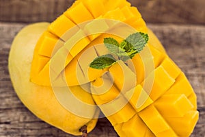 Mango fruit and mango cubes on the wooden table