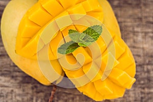 Mango fruit and mango cubes on the wooden table