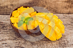 Mango fruit and mango cubes on the wooden table