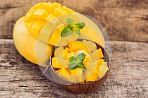 Mango fruit and mango cubes on the wooden table