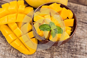 Mango fruit and mango cubes on the wooden table