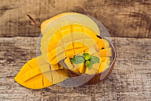 Mango fruit and mango cubes on the wooden table