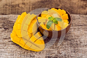 Mango fruit and mango cubes on the wooden table